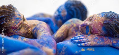 Fotografie wide banner panorama portrait of three sexy young women with dots of white, blue, yellow, purple color paint