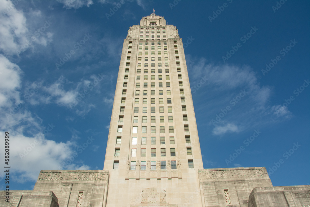 The Art Deco style Louisiana State Capitol seen from the Louisiana Capitol Garden with the cotton clouds and blue sky in downtown Baton Rouge, Louisiana, USA