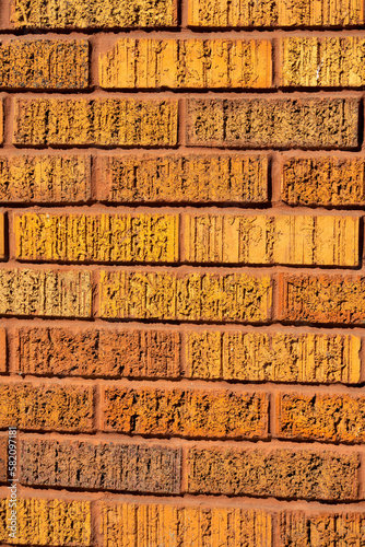 Brick wall with orange textured brick used for design or pattern purposes in urban or industrial area