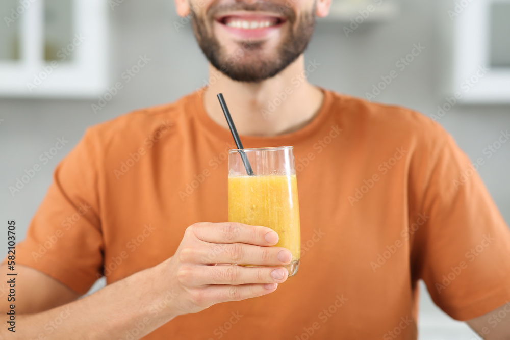Handsome man with delicious smoothie indoors, closeup Handsome man with delicious smoothie indoors, closeup