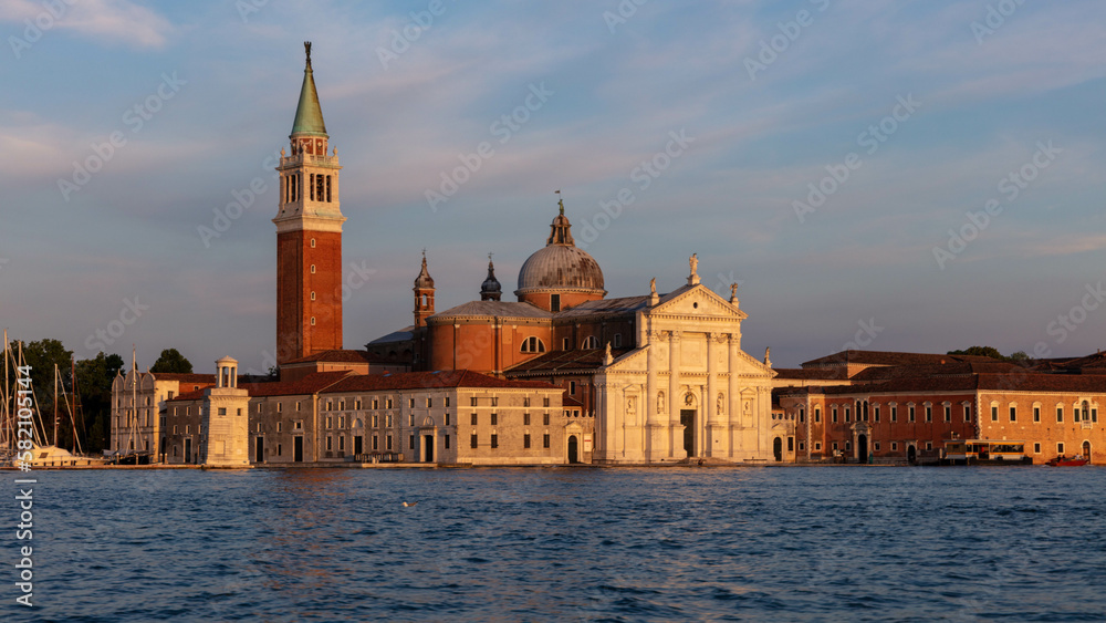 San Giorgio Maggiore is a stunning church located on an island in Venice's lagoon. The church's iconic white facade and towering bell tower provide a striking contrast against blue sky and water.