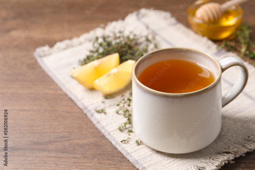 Aromatic herbal tea with thyme on wooden table, space for text Aromatic herbal tea with thyme on wooden table, space for text
