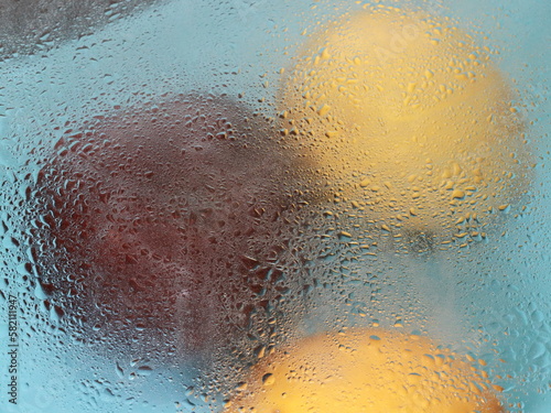 two lemons and a red apple in the rain and water drops abstraction food background photo