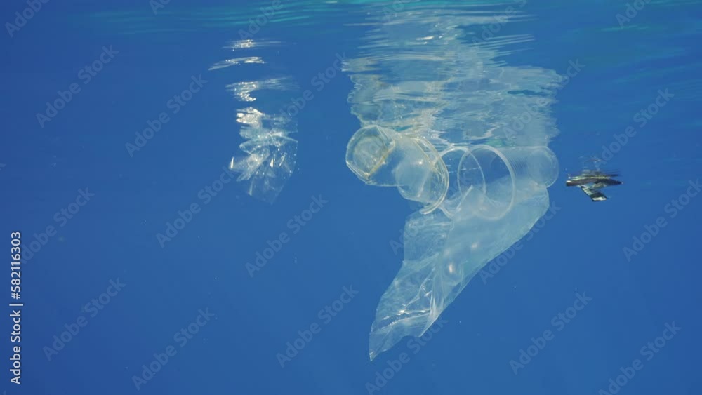 Transparent plastic debris drifting under surface of Ocean, Slow motion ...