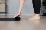 close up of woman preparing a yoga mat for training on the floor at home