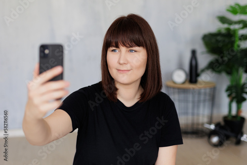 young woman taking selfie photo with smartphone before or after training