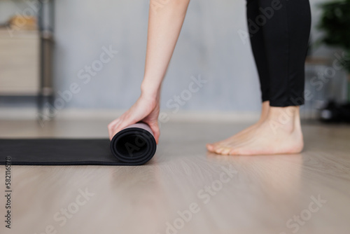 close up of woman preparing a yoga mat for training on the floor at home