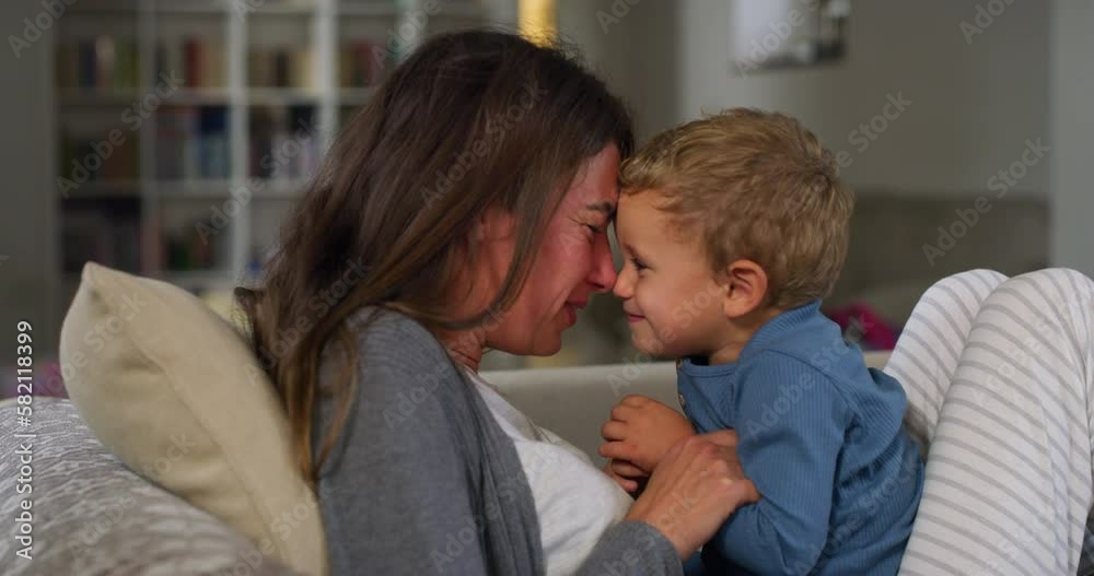 Portrait of Young Woman Playing with her Little Boy During Evening in the Living Room. Little Cute Male Toddler Bonding with his Mom, Enjoying his Time and Laughing. Mother Son Quality Time Portrait of Young Woman Playing with her Little Boy During Evening in the Living Room. Little Cute Male Toddler Bonding with his Mom, Enjoying his Time and Laughing. Mother Son Quality Time