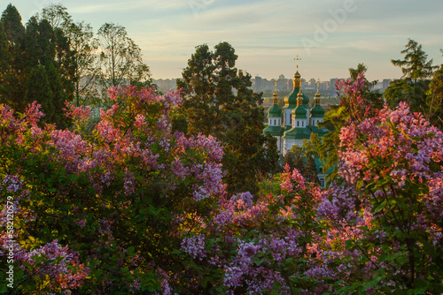 Sunrise view of Kyiv  and the the Vydubychi monastery from Hryshko botanical garden in lilac flowers, Ukaine photo