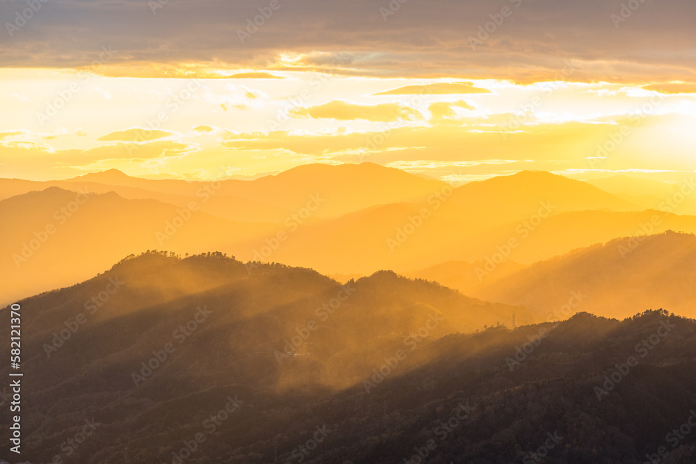 日本　京都府宮津市にある成相山パノラマ展望台から夕焼け空と山々を照らす光芒