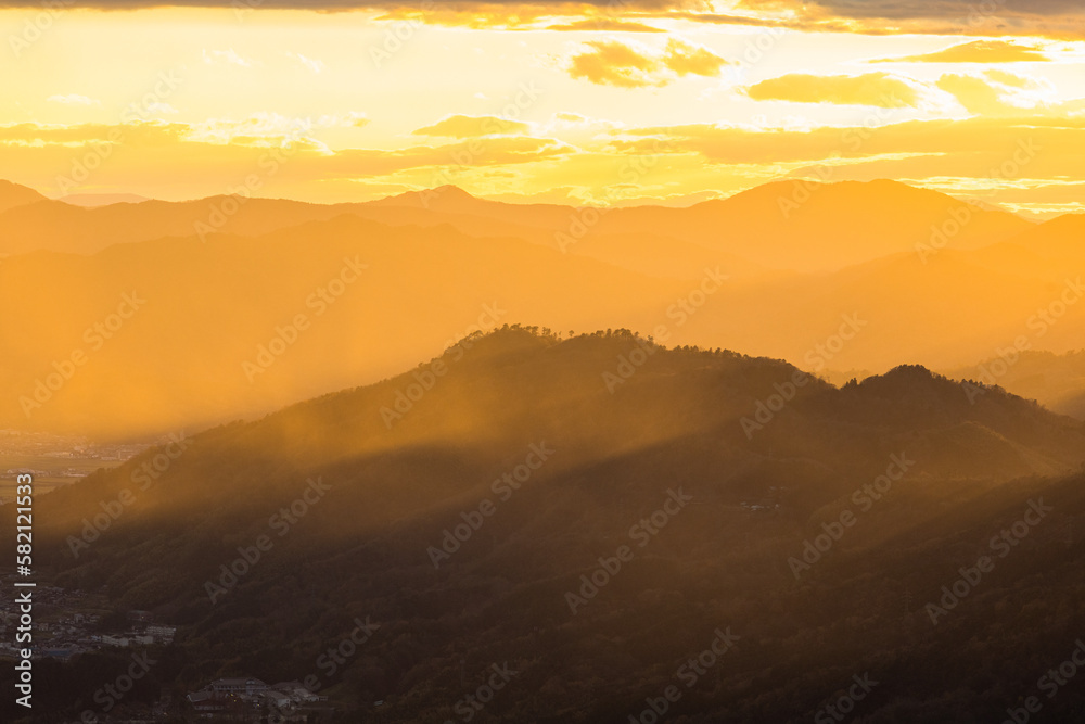 日本　京都府宮津市にある成相山パノラマ展望台から夕焼け空と山々を照らす光芒