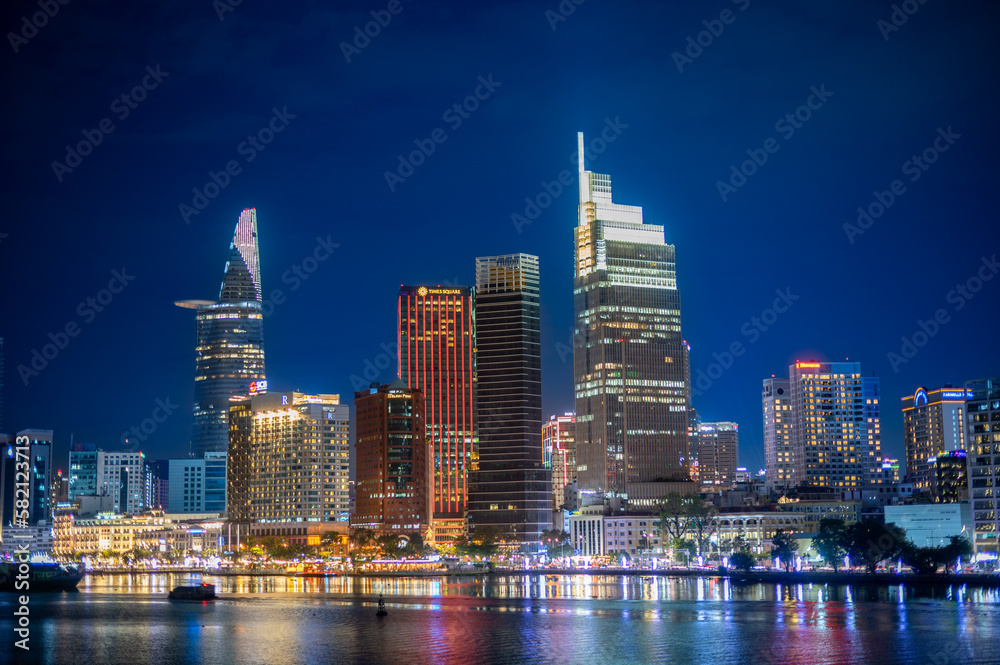 Obraz premium Amazing view of urban city with luminous skyscrapers and road with traffic placed near rippling river at night