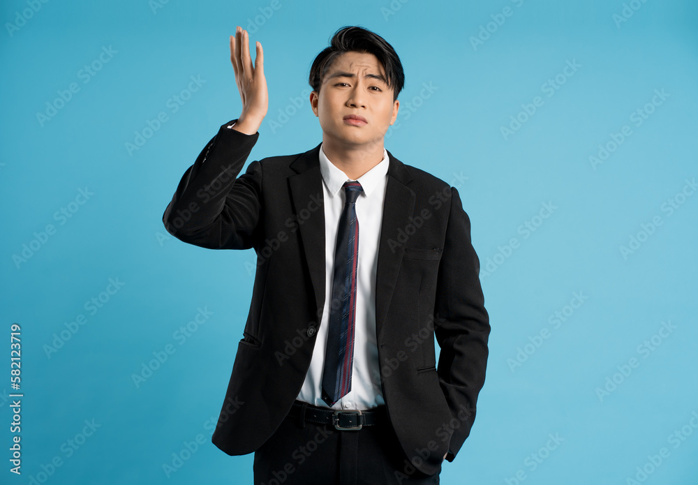 Portrait of young businessman posing on blue background Portrait of young businessman posing on blue background
