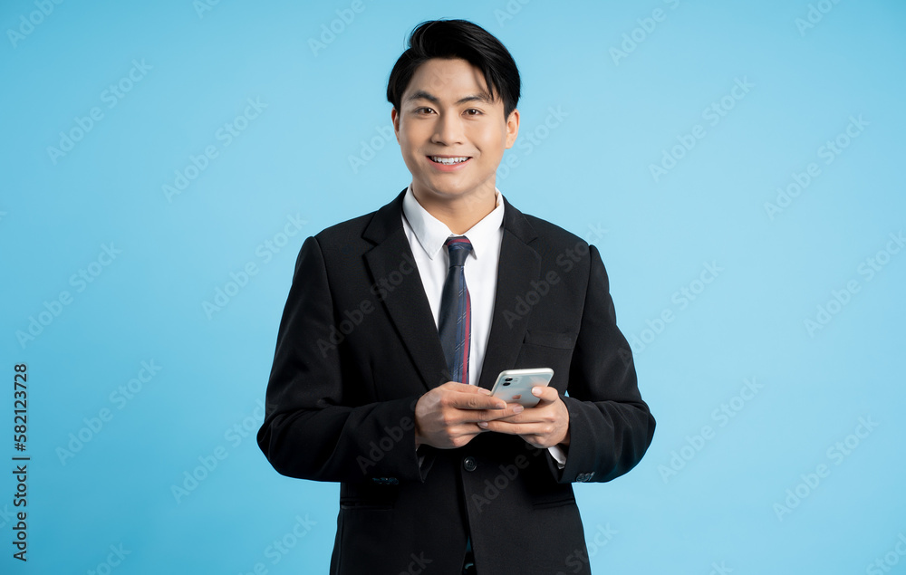 Portrait of young businessman using phone on blue background Portrait of young businessman using phone on blue background