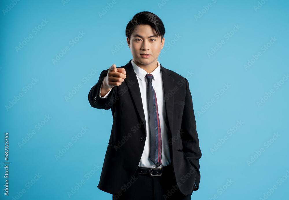 Portrait of young businessman posing on blue background Portrait of young businessman posing on blue background