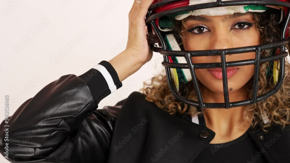 Close shot of a young woman wearing an American football helmet on white background. High quality 4k footage Close shot of a young woman wearing an American football helmet on white background. High quality 4k footage