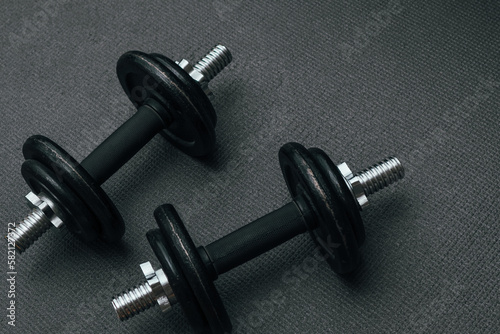 Fitness background. Two 10 kg dumbbells on a gray mat. Sports concept - gray mat, two black dumbbells 10 kg