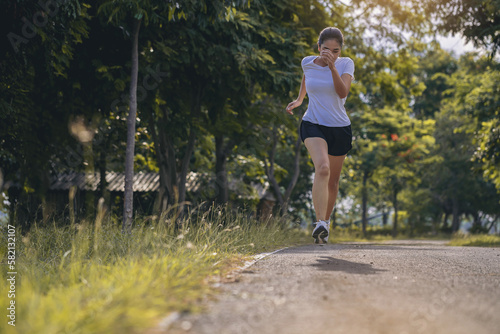 Silhouette of young woman running sprinting on road. Fit runner fitness runner during outdoor workout.