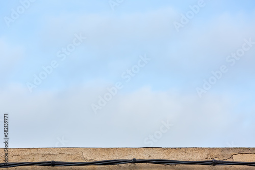 House Ledge with Horizontal Cable and Blue Sky Background