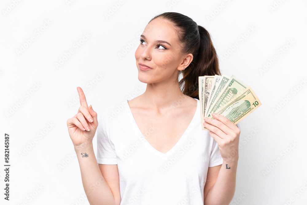 Young caucasian woman taking a lot of money isolated on white background pointing up a great idea Young caucasian woman taking a lot of money isolated on white background pointing up a great idea