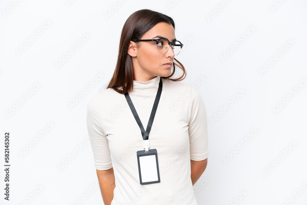 Young caucasian woman with ID card isolated on white background looking to the side