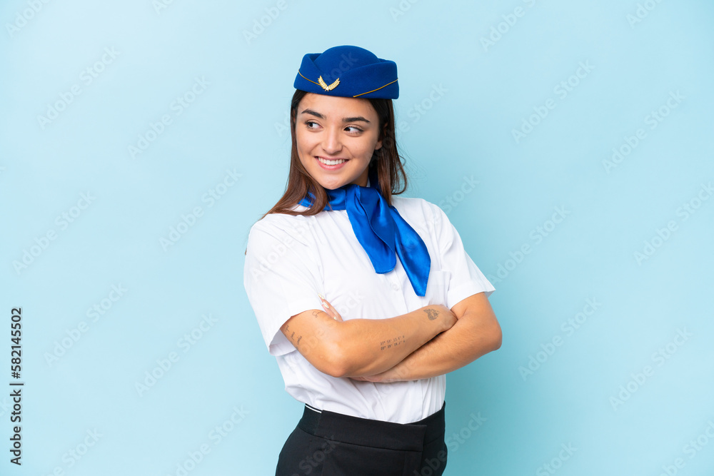 Airplane stewardess caucasian woman isolated on blue background with arms crossed and happy Airplane stewardess caucasian woman isolated on blue background with arms crossed and happy