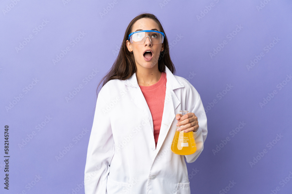 Young scientific woman over isolated background looking up and with surprised expression