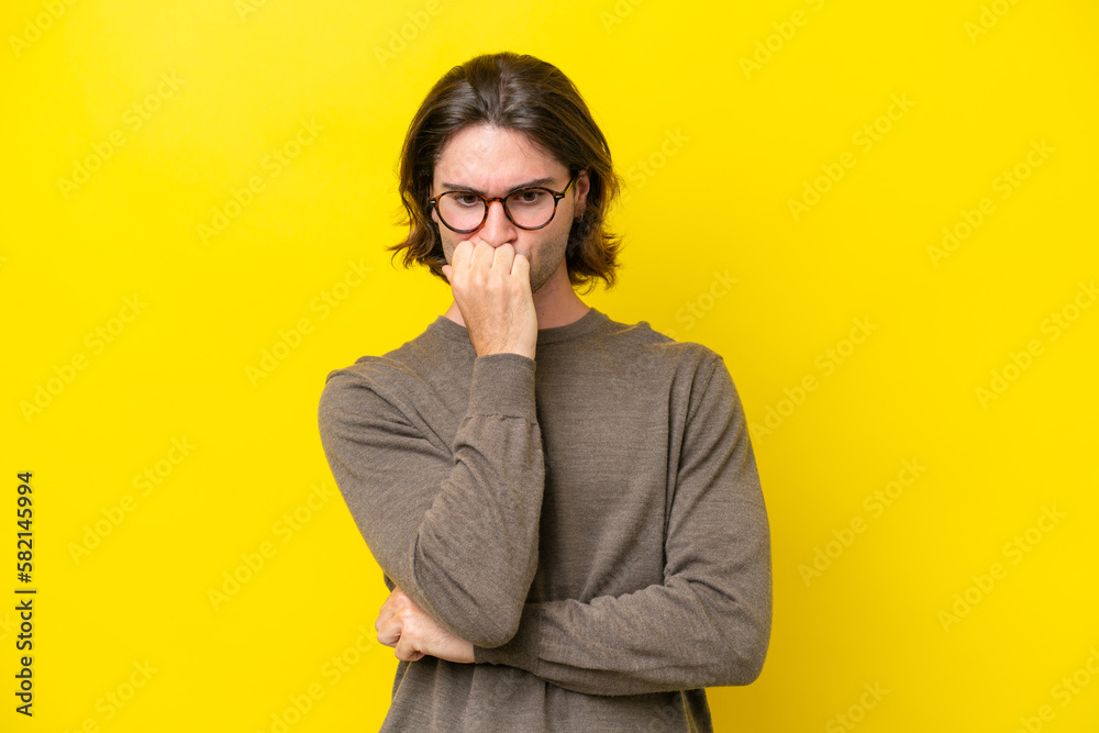 Caucasian handsome man isolated on yellow background having doubts Caucasian handsome man isolated on yellow background having doubts