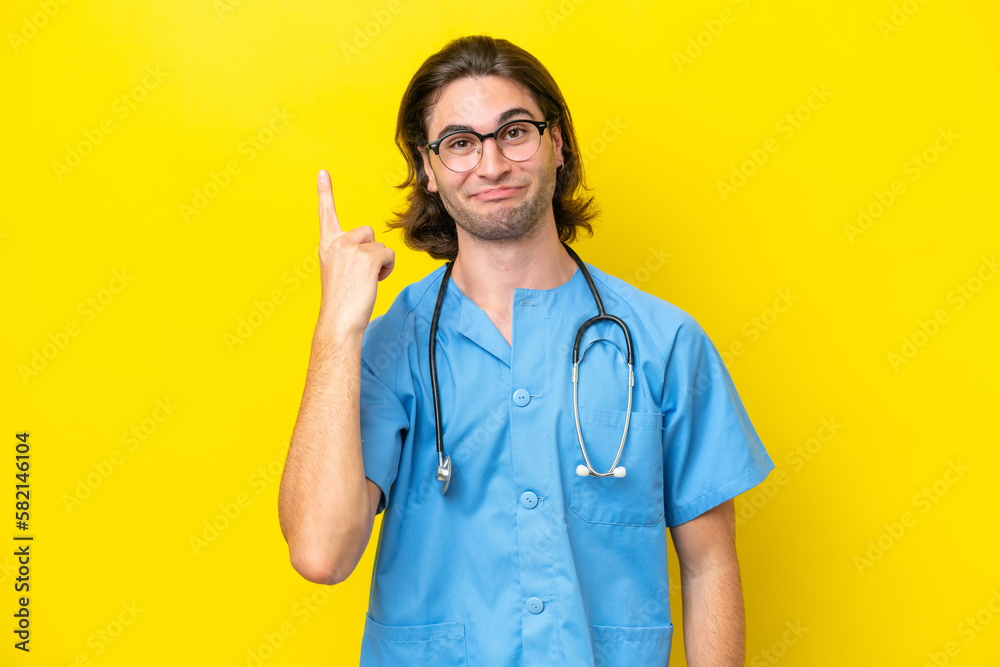Young surgeon caucasian man isolated on yellow background pointing with the index finger a great idea Young surgeon caucasian man isolated on yellow background pointing with the index finger a great idea