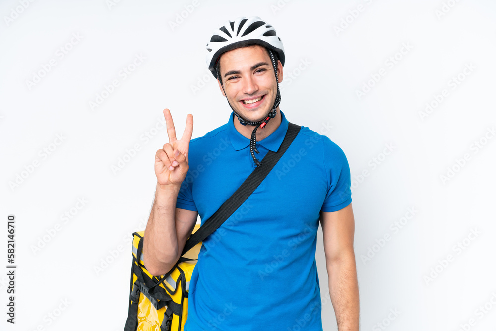 Young caucasian man with thermal backpack isolated on white background smiling and showing victory sign Young caucasian man with thermal backpack isolated on white background smiling and showing victory sign