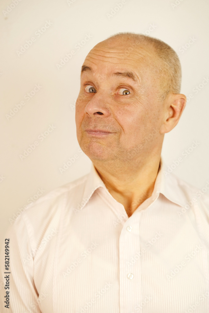 Fototapeta premium close up part of funny male face, goggle eyes,, mature man 60 years old looks in mirror at his reflection, examines face, skin, wrinkles, tracks down personal secrets of neighbors, midlife crisis