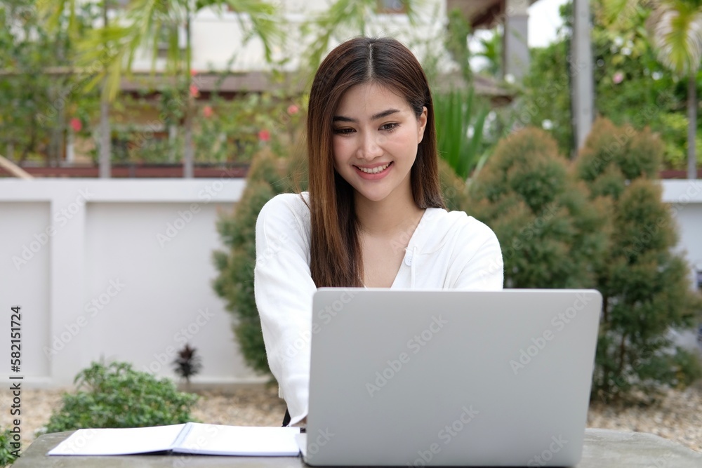 Cheerful smiling mid aged woman using laptop for work Cheerful smiling mid aged woman using laptop for work