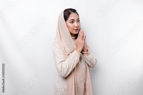 Religious beautiful Asian Muslim girl wearing a headscarf praying to God. photo