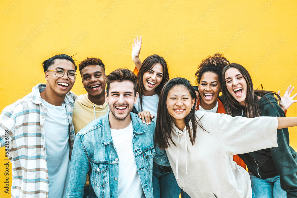 Multiracial group of young people standing in front of yellow isolated background - Youth community concept with guys and girls laughing looking at camera - Bright colors - obrazy, fototapety, plakaty 