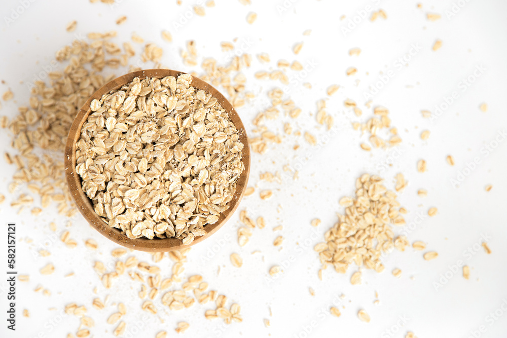 Wooden bowl full of oat flakes on white background. Super food rich in nutrients and that can be used for several recipes. Healthy eating. Top view. Wooden bowl full of oat flakes on white background. Super food rich in nutrients and that can be used for several recipes. Healthy eating. Top view.
