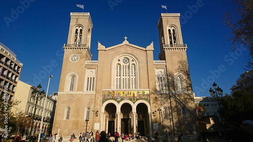 Athens, Greece - Mar 29, 2018: Exterior of the facade of the Metropolitan Cathedral of Athens with visitors in the front under a clear blue sky before the pandemic photo