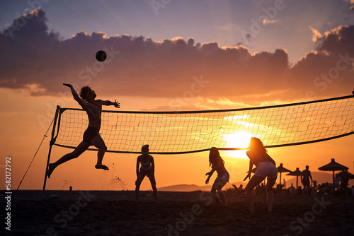 Group of friends playing beach volleyball; Active vacation concept