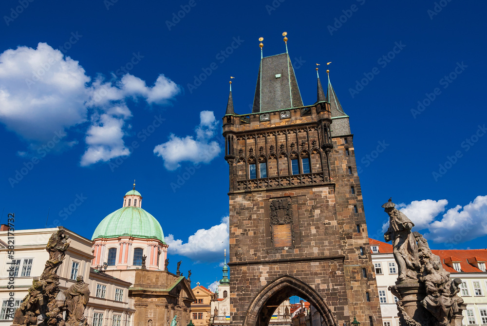 Obraz premium Prague old historical center beautiful architectures with Charles Bridge baroque statues, medieval Old Town Bridge Tower and St. Francis Of Assisi Church beautiful dome