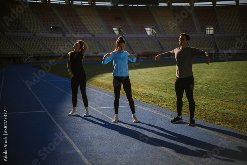 Three sportspeople stretching
