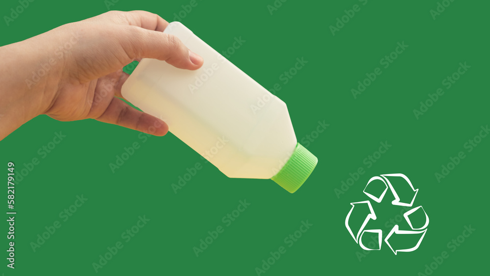 Hand with a plastic bottle, invites to recycle, green color background