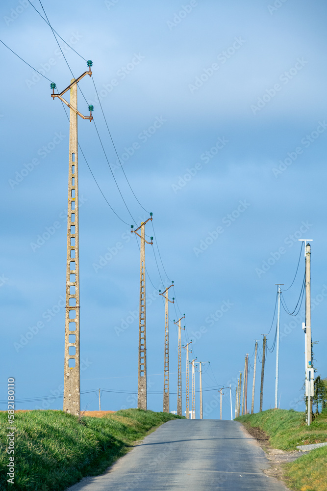 Pylones EDF de ligne moyenne tension le long d'une route ภาพถ่ายสต็อก