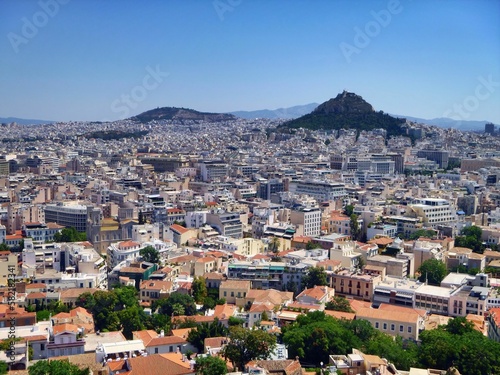 Aerial shot of the cityscape of Athens with hundreds of buildings under the blue sky © Nigel Harris/Wirestock Creators