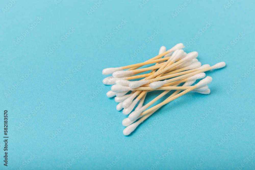 Cotton buds on a blue background.Eco-friendly materials. Wooden, cotton swabs on a white background.Bamboo swabs and cotton flowers.Zero waste, plastic free lifestyle concept.Place for text. Cotton buds on a blue background.Eco-friendly materials. Wooden, cotton swabs on a white background.Bamboo swabs and cotton flowers.Zero waste, plastic free lifestyle concept.Place for text.