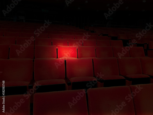 映画館のスポットライトで浮かぶ赤の1座席