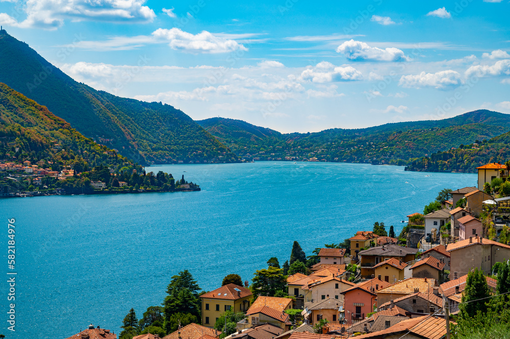 Panorama of Lake Como and the shore of Como, with villages and mountains above.