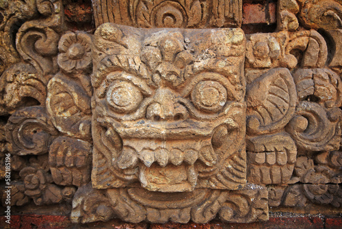 Bali sculpture in stone wall.
