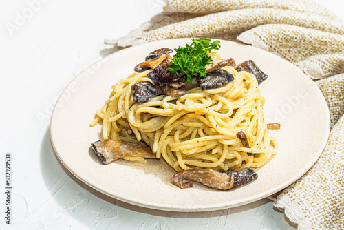 Spaghetti pasta with oyster mushrooms, creamy sauce and parsley. Healthy vegan food ready to eat