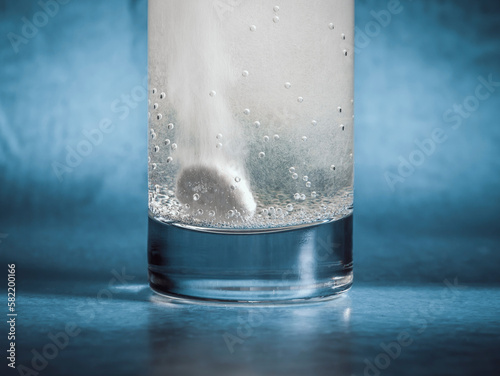 Close up detail with a Effervescent vitamin C tablet dissolving in a glass of water