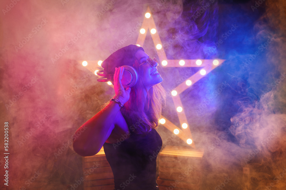 Background room with dancing girl in headphones - spotlights and lights, abstract purple background with neon glow Background room with dancing girl in headphones - spotlights and lights, abstract purple background with neon glow