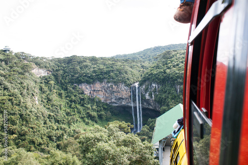 a view from the side of a train, looking out at a large waterfall photo